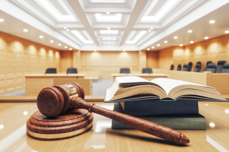 Interior of an empty courtroom with gavel and law books.