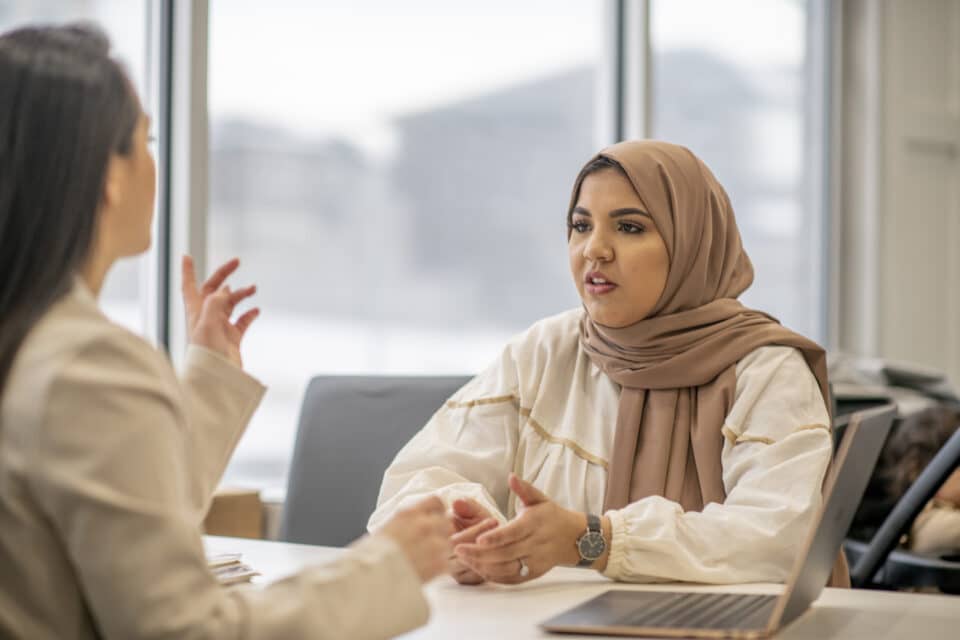 A female Muslim woman is speaking to her public defender.