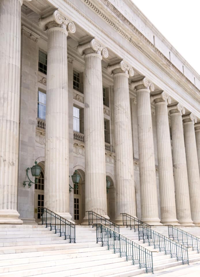The front of a court house with Roman columns.
