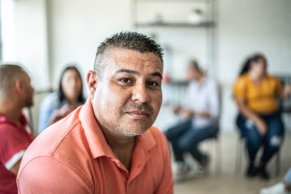 Portrait of mid adult man during group therapy